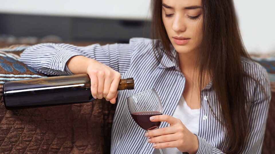 Depressed Woman Drinking Wine Indoors